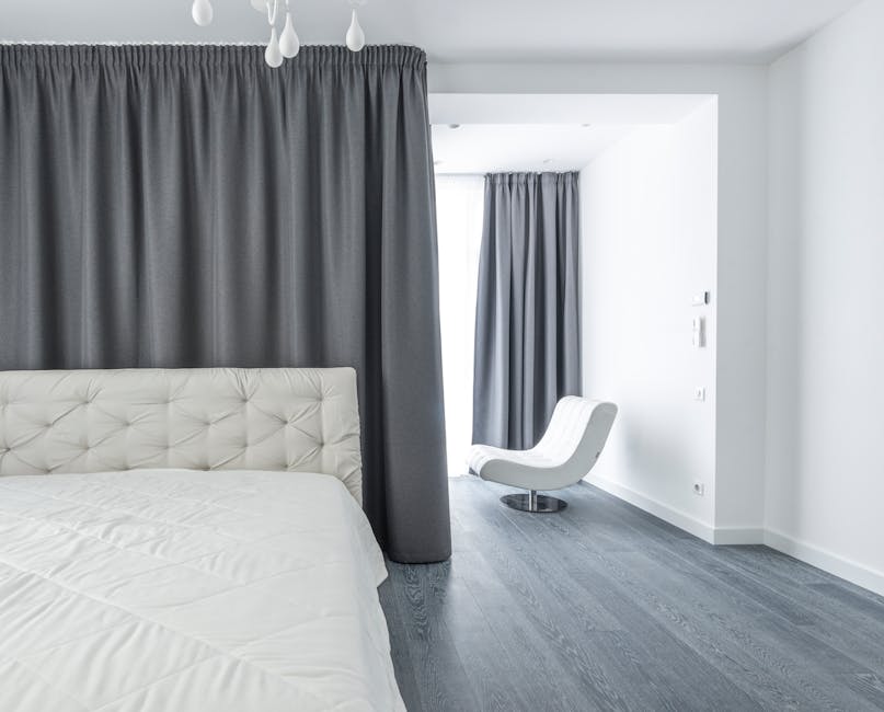 Elegant custom drapes and blackout curtains in a master bedroom